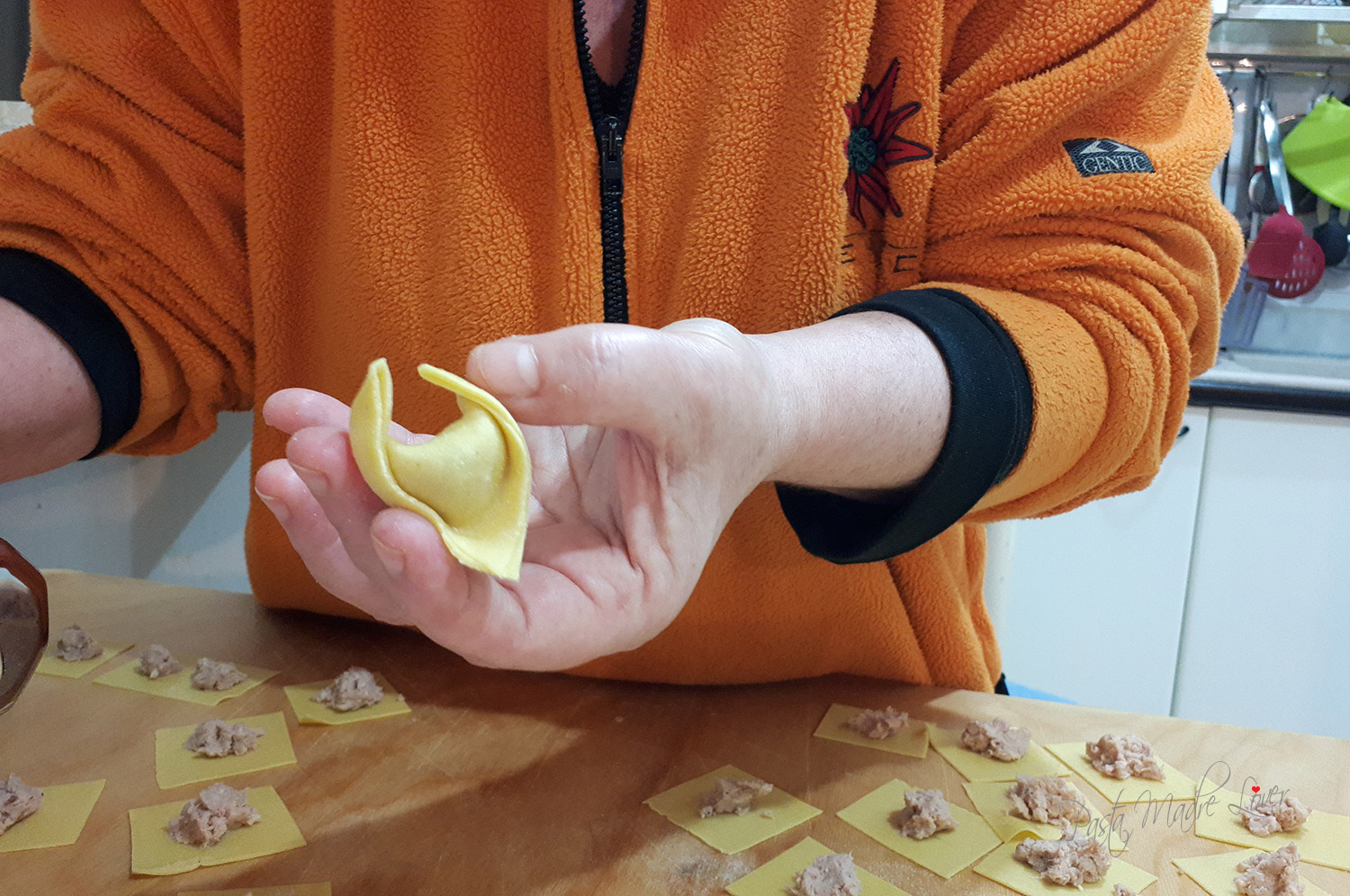 cappelletti ferraresi: piegatura del secondo lato del triangolo di pasta sfoglia